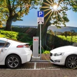 Zwei weiße E-Autos laden nebeneinander an einer Ladesäule - In diesem Beitrag werden die Schwierigkeiten für Elektrotransporter in ländlichen Gebieten und aktuelle Lösungsansätze vorgestellt.