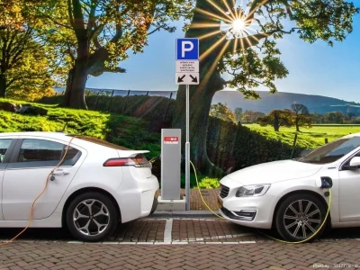 Zwei weiße E-Autos laden nebeneinander an einer Ladesäule - In diesem Beitrag werden die Schwierigkeiten für Elektrotransporter in ländlichen Gebieten und aktuelle Lösungsansätze vorgestellt.